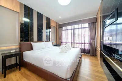 Luxurious bedroom with elegant decor and large window offering natural light