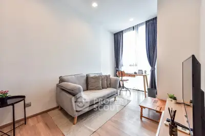 Modern living room with cozy sofa and natural light, perfect for relaxation and work-from-home setup.
