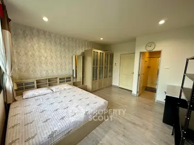 Spacious bedroom with modern decor and ample storage in a stylish apartment.