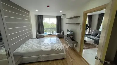 Modern bedroom with balcony and stylish living area, perfect for urban living.