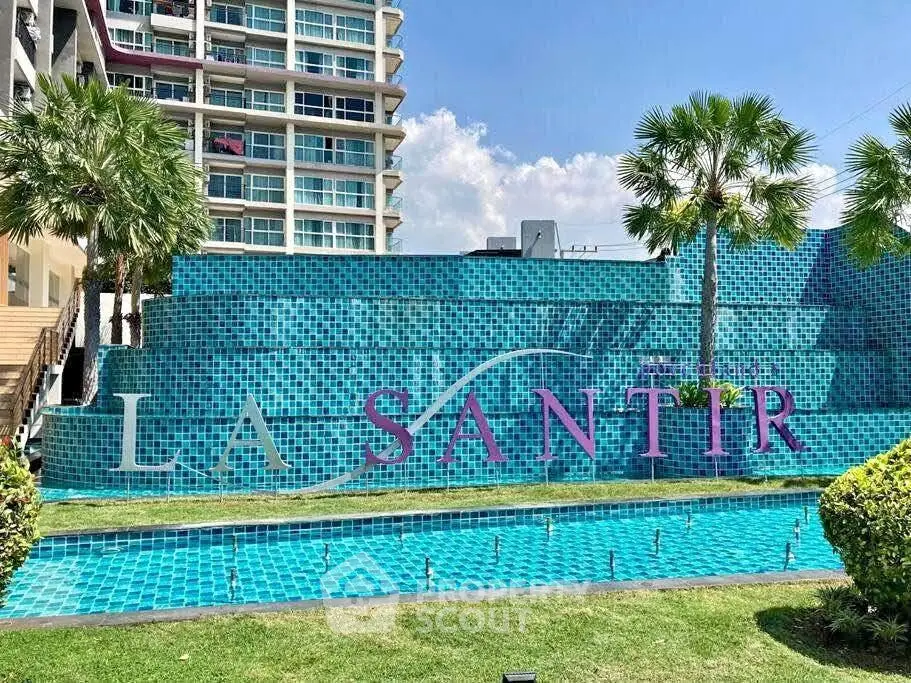 Modern condominium exterior with pool and lush greenery at La Santir.