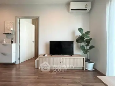 Modern living room with sleek wooden flooring, TV unit, and air conditioning, perfect for cozy relaxation.