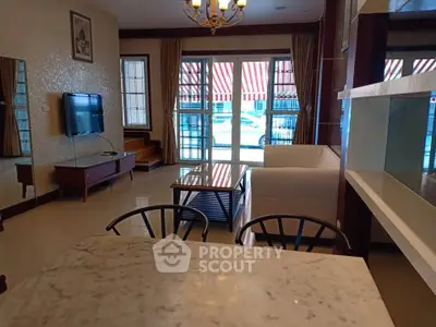 Spacious living room with modern decor and natural light, featuring a cozy sofa and wall-mounted TV.