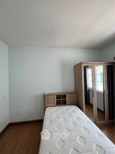 Cozy bedroom with single bed and mirrored wardrobe, perfect for minimalist living.