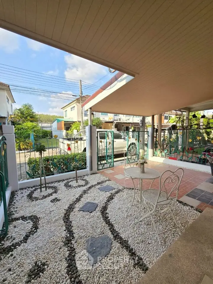 Charming garden patio with stylish outdoor seating and decorative stone pathway.