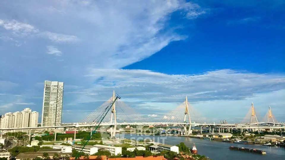 Stunning cityscape view with modern bridge and high-rise buildings under a vibrant blue sky.