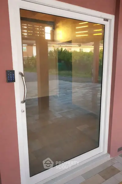 Modern glass door with keypad entry in stylish residential property