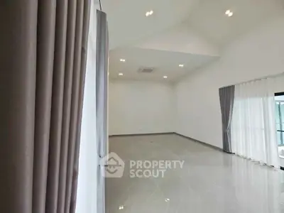 Spacious modern living room with high ceilings and elegant curtains