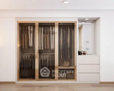 Modern walk-in closet with sliding glass doors and organized storage space.