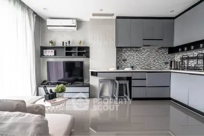 Modern open-layout kitchen and living room with sleek design and natural light.