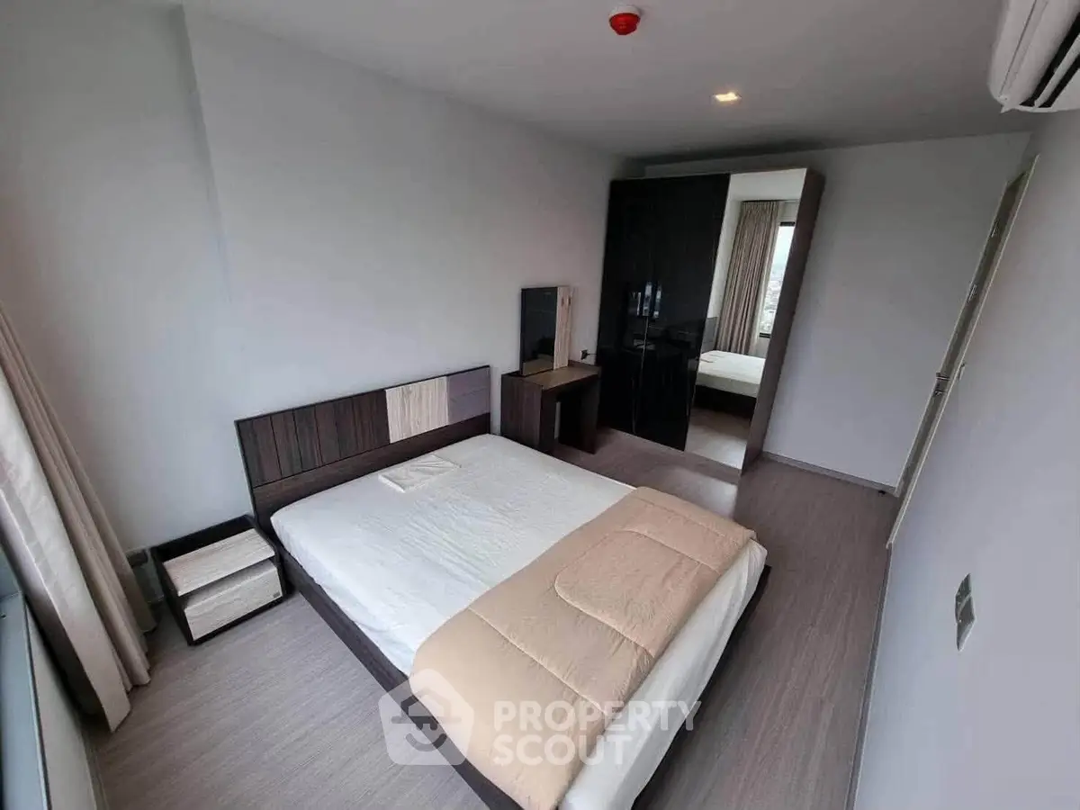 Modern bedroom with sleek design and ample natural light, featuring a comfortable bed and stylish furniture.