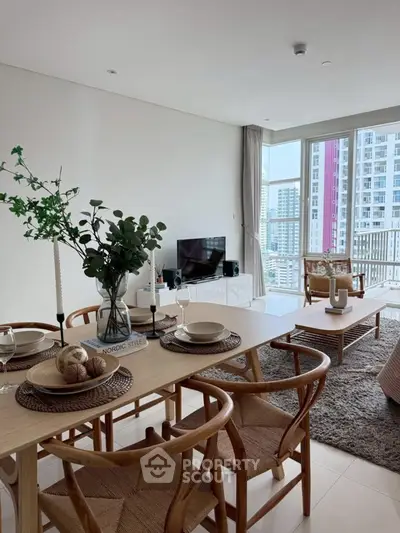 Modern living room with stylish dining area and city view, featuring elegant decor and natural light.