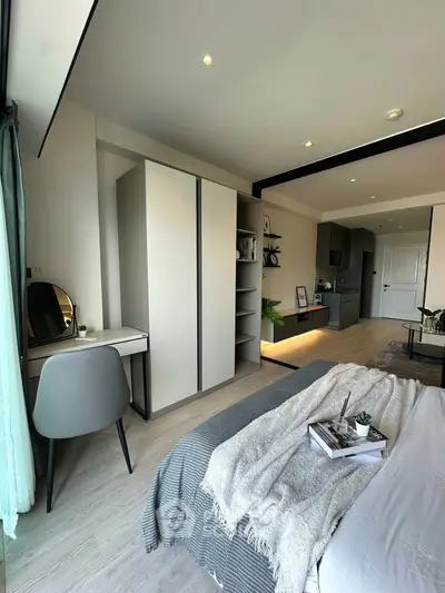 Modern bedroom with stylish decor and open layout, featuring a cozy bed and sleek furniture.