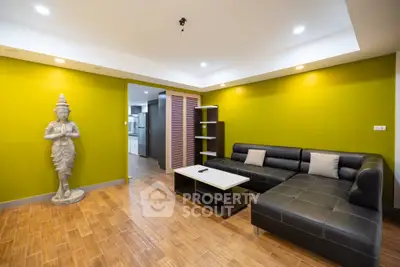 Stylish living room with vibrant yellow walls and modern black leather sofa.