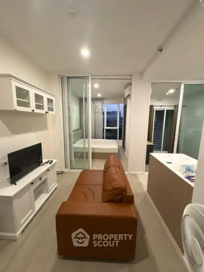Modern apartment interior with open layout, featuring a cozy living room and adjacent bedroom.