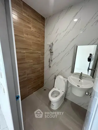 Modern bathroom with wood accent wall and sleek fixtures