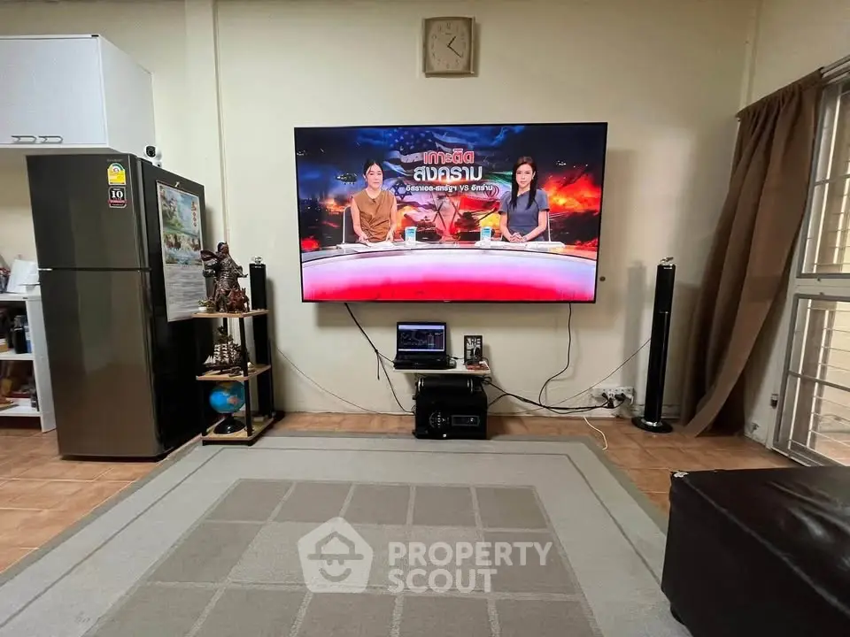 Cozy living room with large TV and modern decor, perfect for relaxation.