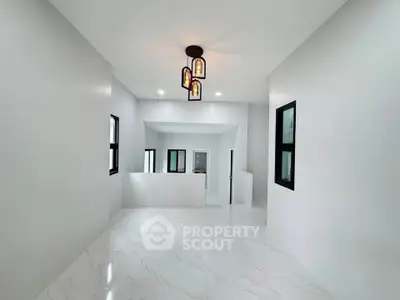 Spacious modern interior with elegant lighting and sleek white flooring, perfect for contemporary living.