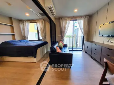Modern studio apartment with cozy living area and balcony view