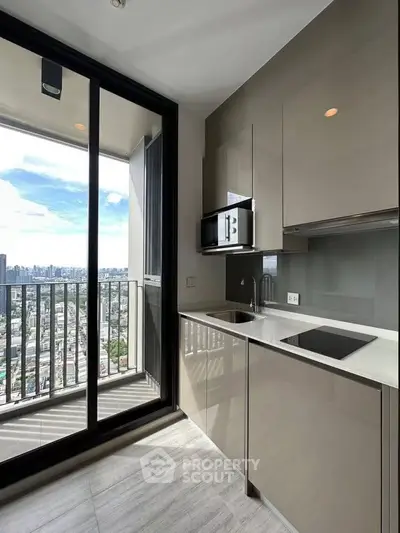 Modern kitchen with sleek cabinetry and stunning city view from balcony.